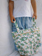 A child holding the paradise palm wet bag from The Luxe Journey